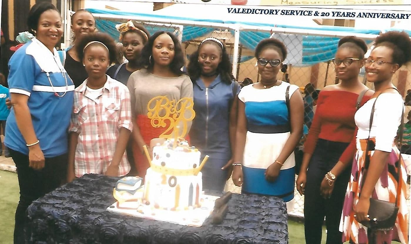 Pupils gathered around the B&B @ 20 cake under the Valedictory Service & 20 Years Anniversary banner, July 2017